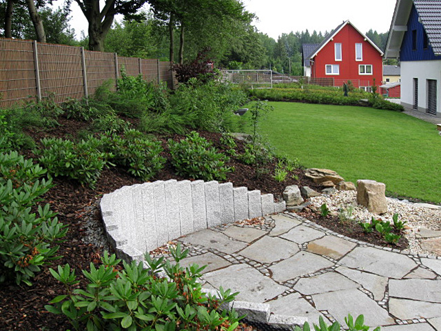 Referenzbild: 108 Terrasse aus polygonalen Naturstein schmiegt sich an den angepflanzten Hang.