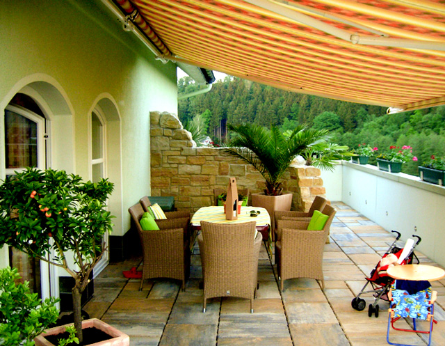 Referenzbild: 21 Terrasse mit Raumteilung aus einer geschwungenen Sandsteinmauer.