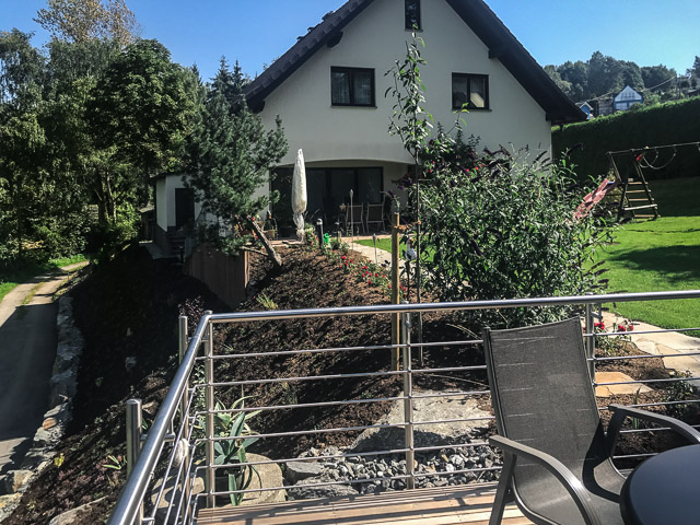 Referenzbild: 386 Ein kleiner Balkon macht die Böschungsbepfanzung erlebbar. Den Böschungsfuß stabilisieren und zieren großformatige Natursteine. Kurz nach der Fertigstellung.