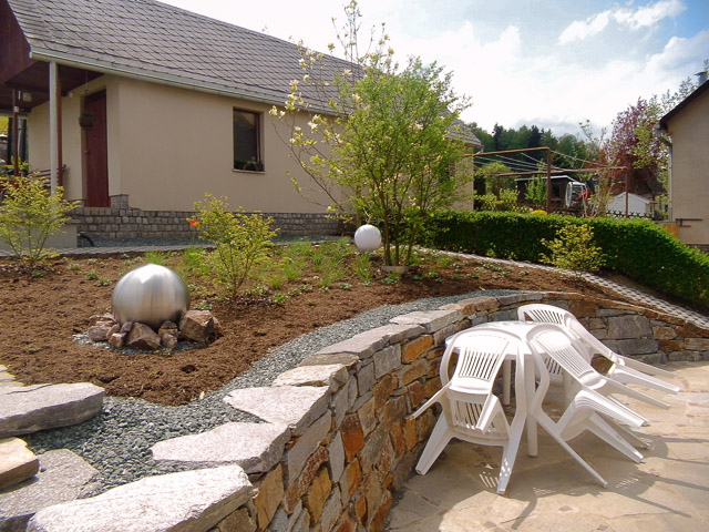 Referenzbild: 418 Eine Trockenmauer fasst eine Terrasse aus Polygonalem Plattenbelag und leitet zur angrenzenden Pflanzfläche über